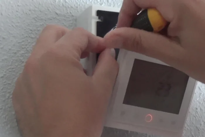 Atornilla el soporte del termostato a la caja de registro (superficial o incrustada). Coloca la pantalla sobre el soporte.