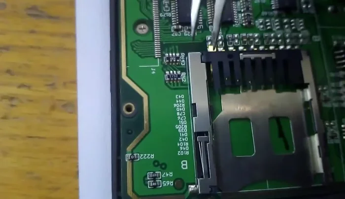 Enderezar el pin doblado de la tarjeta SD con cuidado. Se observa que otro pin también tiene mal contacto.